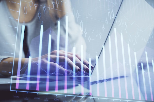 Double exposure of woman hands typing on computer and financial graph hologram drawing Stock market analysis concept
