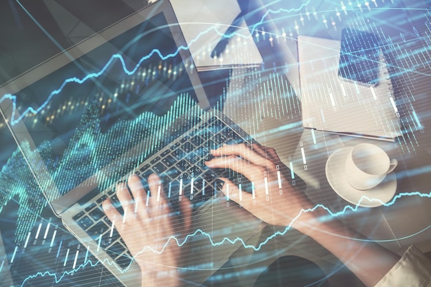 Double exposure of woman hands typing on computer and forex chart hologram drawing Stock market invest concept