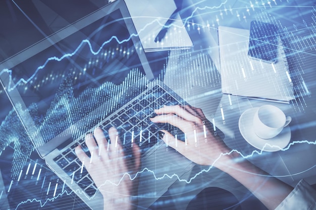 Double exposure of woman hands typing on computer and forex chart hologram drawing Stock market invest concept