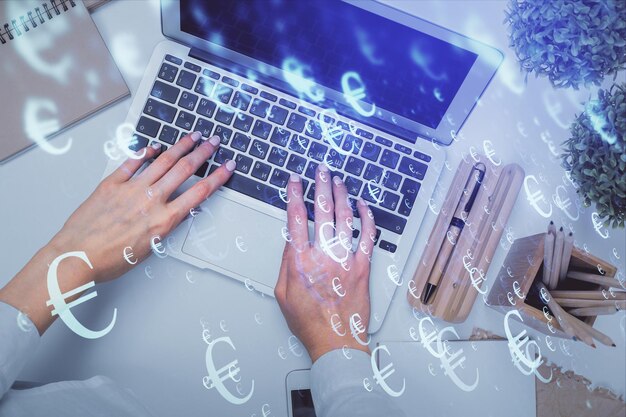 Double exposure of woman hands working on computer and forex graph hologram drawing Top View Financial analysis concept