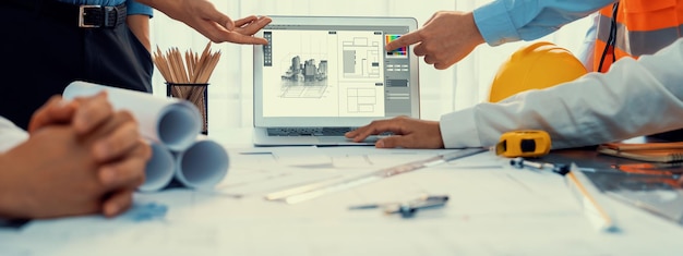 Engineer and architect working together brainstorming and designing blueprint using laptop working with architectural software for precise digital interior or structure design Insight