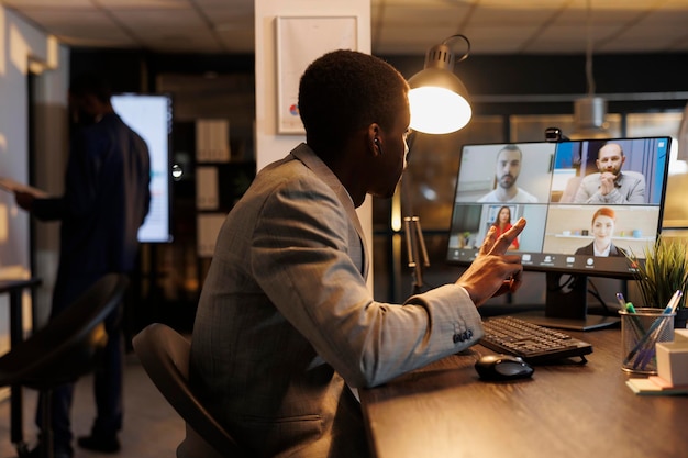 Executive manager planning company investment with remote colleagues during online videocall meeting conference. Diverse team working late at night at marketing strategy. Business concept