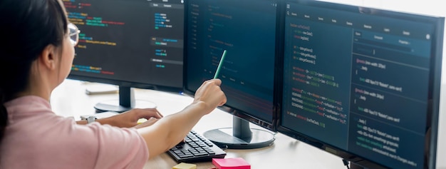 Female programer explain while pointing code displayed on computer Burgeoning