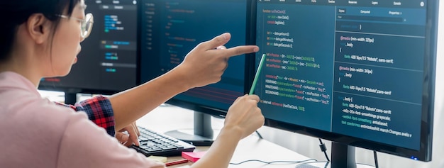 Female programer explain while pointing code displayed on computer Professional programmer present data analysis and writing java script at modern company office Closeup Burgeoning