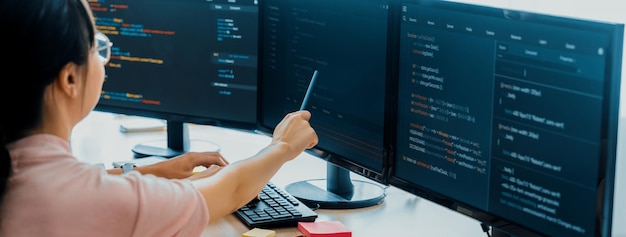 Female programer explain while pointing code displayed on computer Professional programmer present data analysis and writing java script at modern company office Closeup Burgeoning