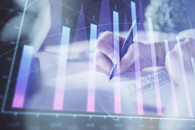 financial forex graph displayed on hands taking notes background concept of research multi exposure