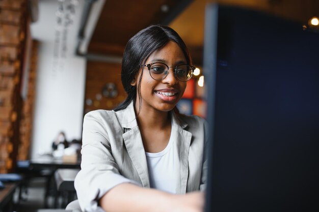 Focused young african american businesswoman or student looking at laptop serious black woman working or studying with computer doing research or preparing for exam online