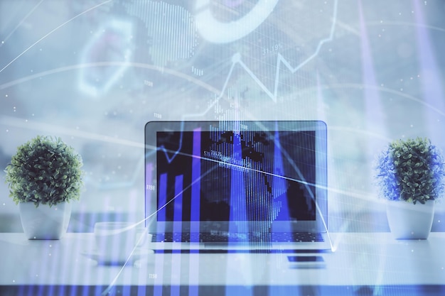 forex graph hologram on table with computer background multi exposure concept of financial markets