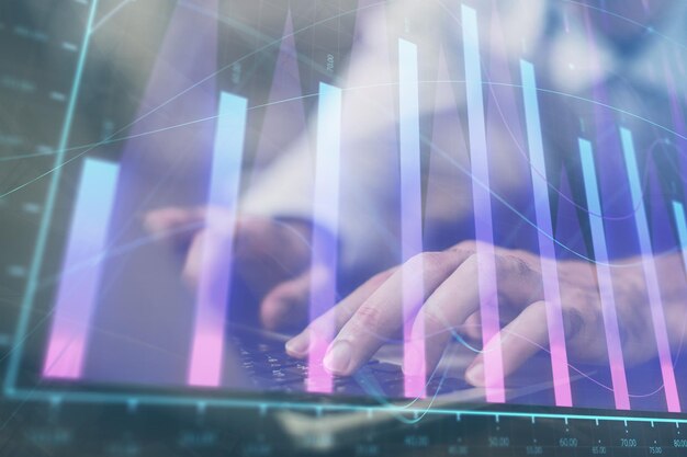forex graph with businessman working on computer in office on background concept of hardworking multi exposure