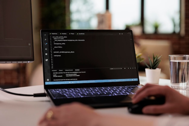Freelance software app developer using terminal windows at home, programming security firewall, running css html script. Programmer developing new user interface online cloud server. Close up.