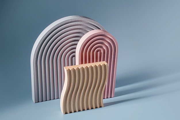 Gray and pink arches and wooden plate with waves  on a blue background