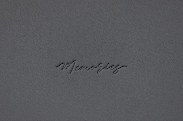 gray leather texture closeup with the word memories embossed