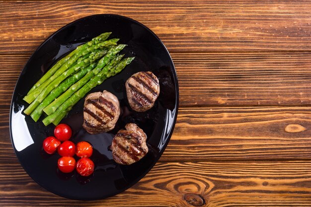 grilled filet mignon with asparagus and tomatoes beef sreak on rustic background