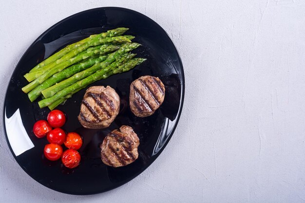grilled filet mignon with asparagus and tomatoes beef sreak on rustic background