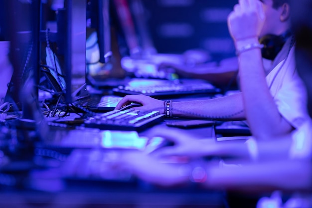 Group of guys collectively play an online game in a competition in blue lighting  esports