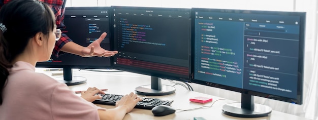 Group of professional web developer discuss about data analysis while computer screen show computer code at modern office Close up Digital engineering and web development concept Burgeoning