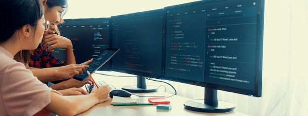 Group of professional web developer discuss about data analysis while computer screen show computer code at modern office Close up Digital engineering and web development concept Burgeoning