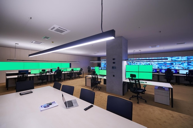 Group of Security data center operators working in a CCTV monitoring room looking on multiple monitors  Officers Monitoring Multiple Screens for Suspicious Activities  Team working on the System Contr