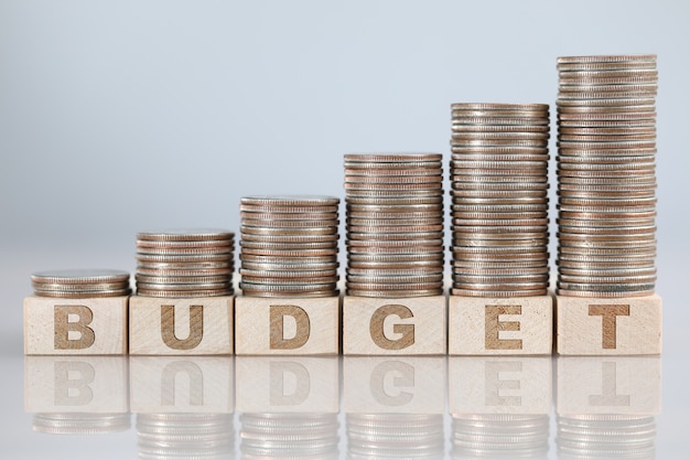Growing pile of silver coins standing at budget sign closeup