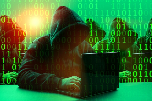 Hacker group Dangerous hooded group of hackers Internet cyber crime cyber attack system breaking and malware concept Dark face Digital binary code on background