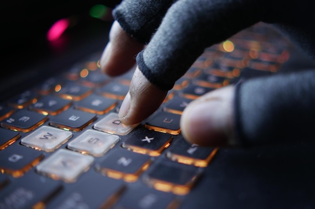 Hacker hand stealing data from laptop top down