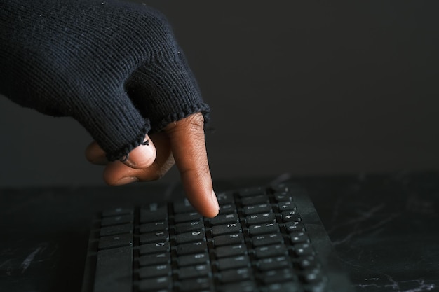Hacker hand stealing data from laptop top down