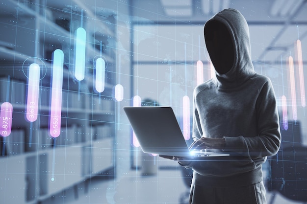 Hacker in hoodie using laptop in blurry office interior with creative glowing business graph and map Global investment theft and malware concept Double exposure