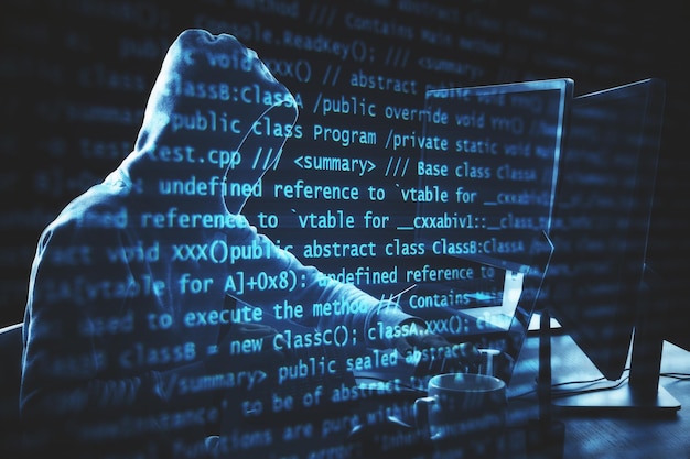 Hacker using computer with programming code