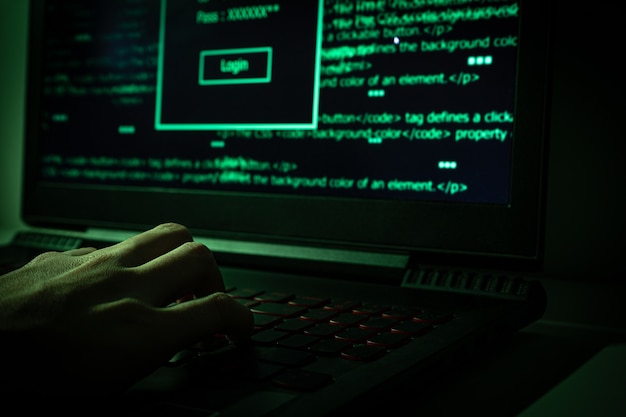 Hacker using laptop into dark web.