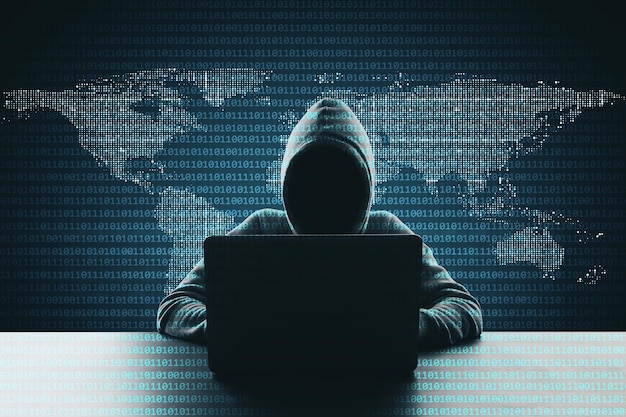 Hacker using laptop on abstract binary code map background Hacking and phishing concept