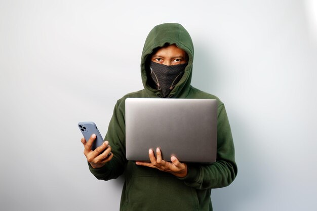Hacker using laptop to steal personal data from people and calling someone to request a ransom isolated on white background