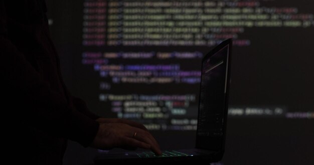 Hacker writing code cracking computer Programming code in the background Hacker attack cybercrime