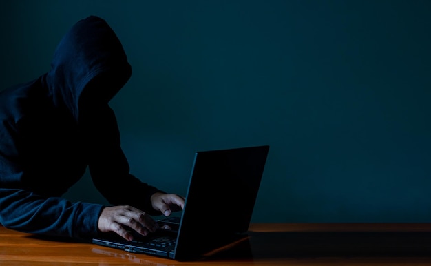 hackers work on laptops in the dark the concept of information security in the internet network .