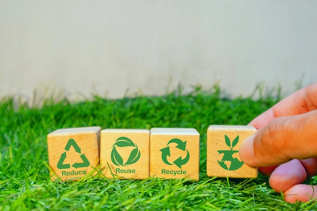 Hand holding wooden blocks with reduce reuse recycle symbol Environmental concept