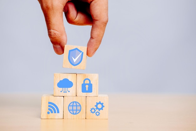 Hand holding wooden cube with icons security, Cybersecurity protection and data security concept.
