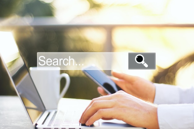 hand using smartphone laptop with internet browser search bar
