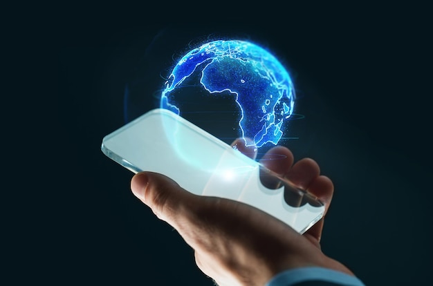 hand with smartphone and earth hologram