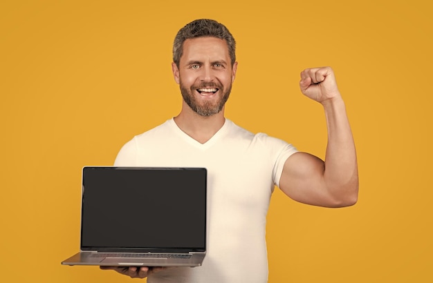 happy man showing laptop app in studio man showing app on laptop man showing app