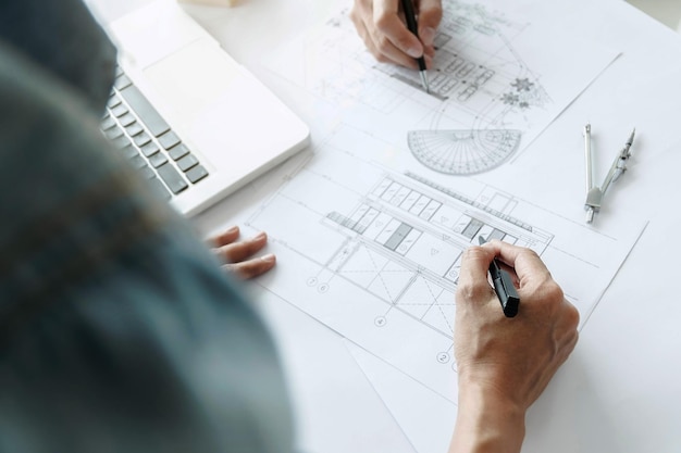 High angle view of architects working over blueprint at desk