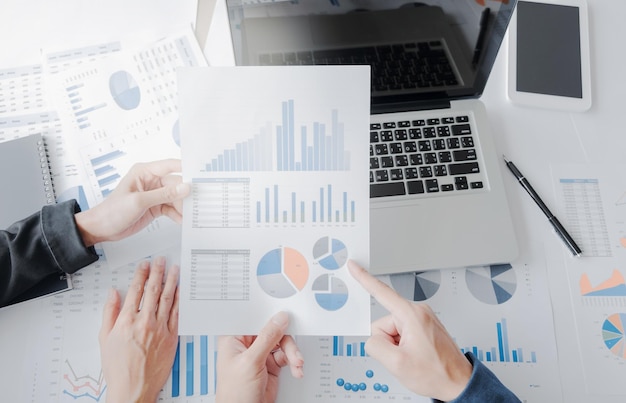 High angle view of business people discussing over graphs at desk
