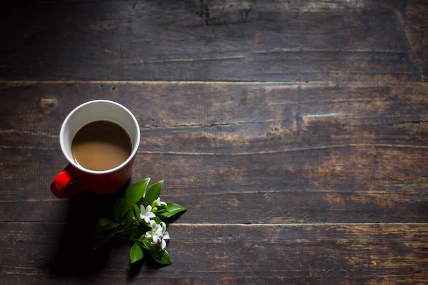 High angle view of coffee cup with flowers on wooden table