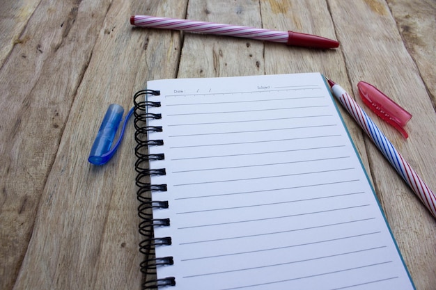 High angle view of notebook and pens on table