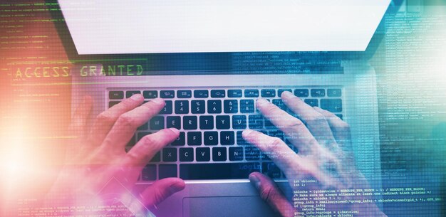 Holografiset kädet ja henkilö kannettavan tietokoneen kanssa, ohjelmoija ja koodaus internet-yhteydellä ja näppäimistöllä. Mallikuva tila hakkerille ja järjestelmälle tietokoneen peitekerroksella ja kyberturvallisuudella sekä ohjelmistopäivityksellä