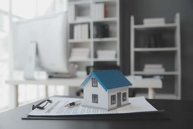 House model with real estate agent and customer discussing for contract to buy house insurance or loan real estate background