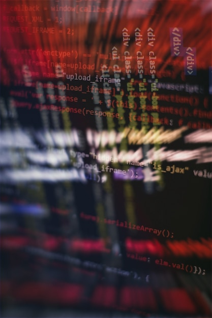 HTML5-koodia muokkaustyökalussa verkkosivujen kehitykseen. Verkkosivun HTML-koodi läppärin näytöllä, lähikuva.
