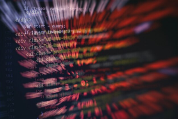 HTML5-koodia muokkaustyökalussa verkkosivujen kehitykseen. Verkkosivun HTML-koodi läppärin näytöllä, lähikuva.