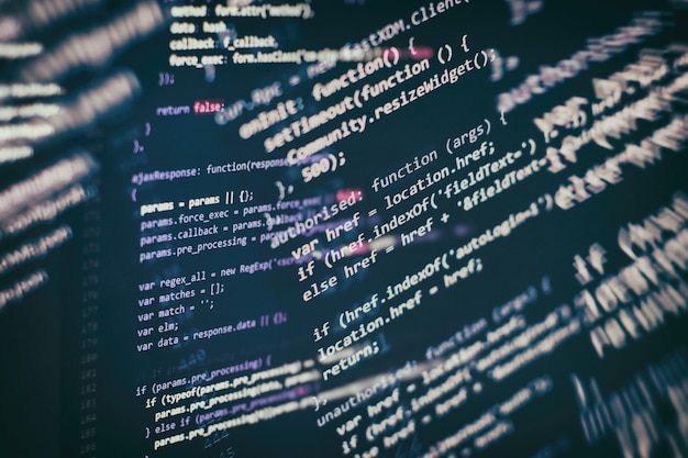 HTML5-koodia muokkaustyökalussa verkkosivujen kehitykseen. Verkkosivun HTML-koodi läppärin näytöllä, lähikuva.