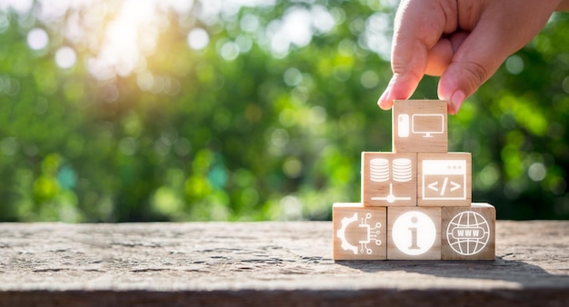 information technology concept man hand holding wooden block with information technology icon on virtual screen