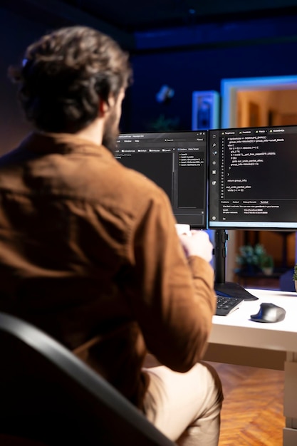 IT admin inspecting coding on desktop PC looking to fix potential issues