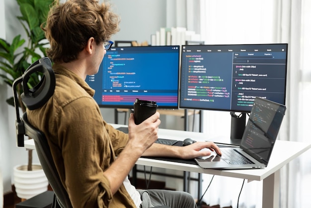 IT developer holding coffee cup with looking online software on pc Gusher